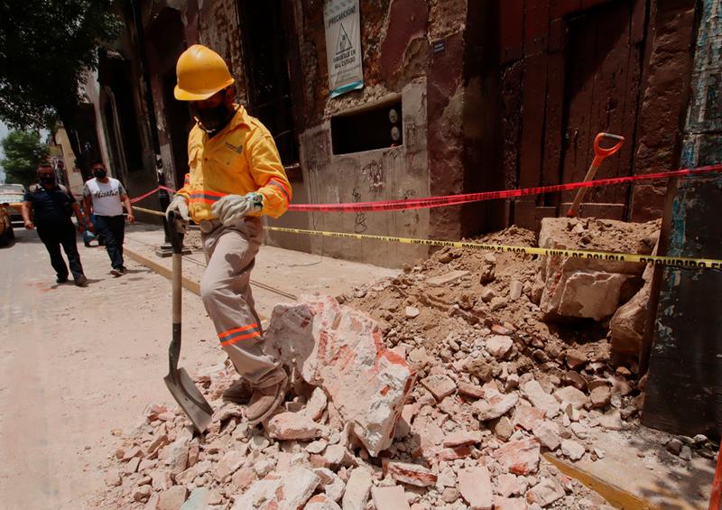 Trabajador retira escombros Aumenta a cinco fallecidos tras el sismo de magnitud 7,5